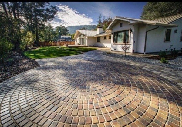 Circular pattern interlocking paver driveway leading to modern home
