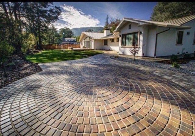 Circular pattern interlocking paver driveway leading to modern home
