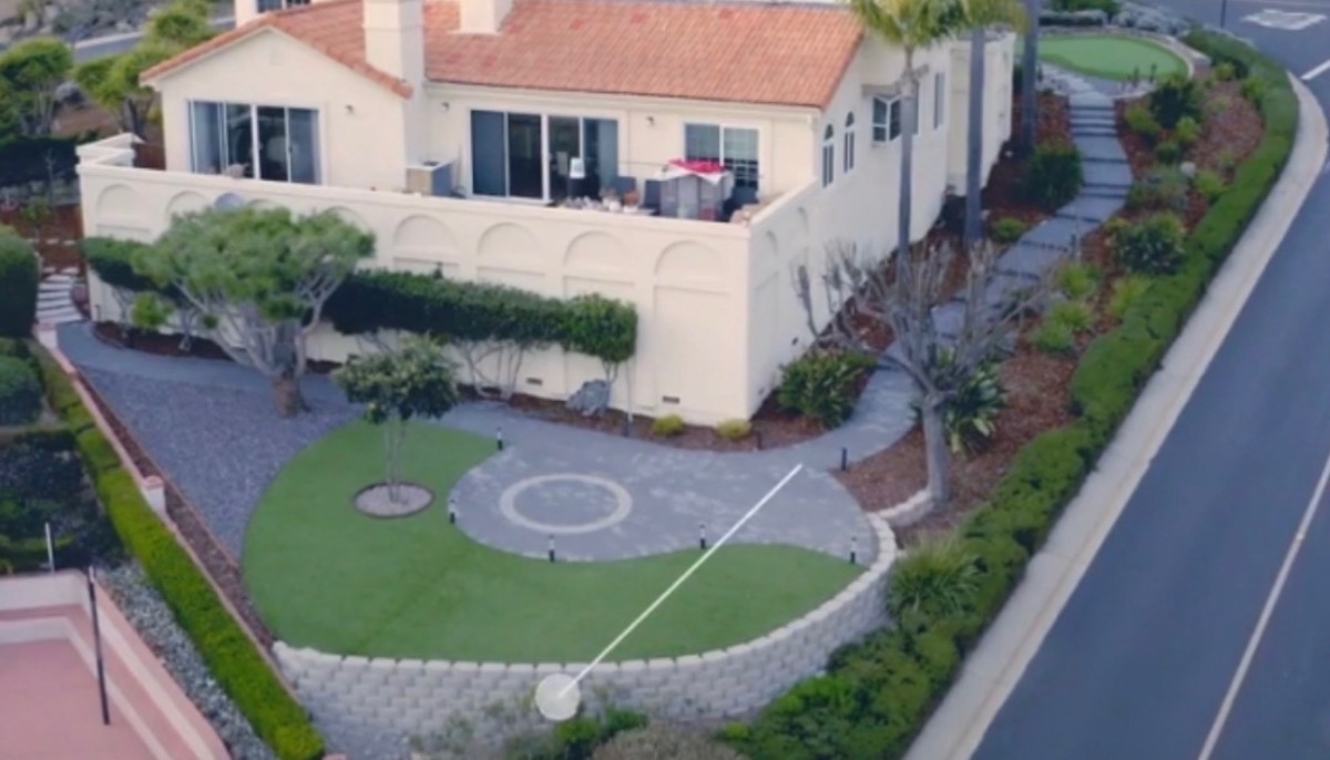 Aerial view of Mediterranean estate with synthetic turf putting green and circular paver design