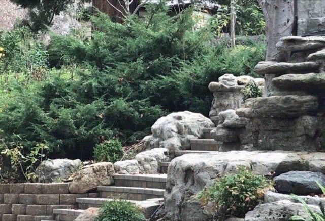 Naturalistic stacked boulder rock formation with built-in stone steps