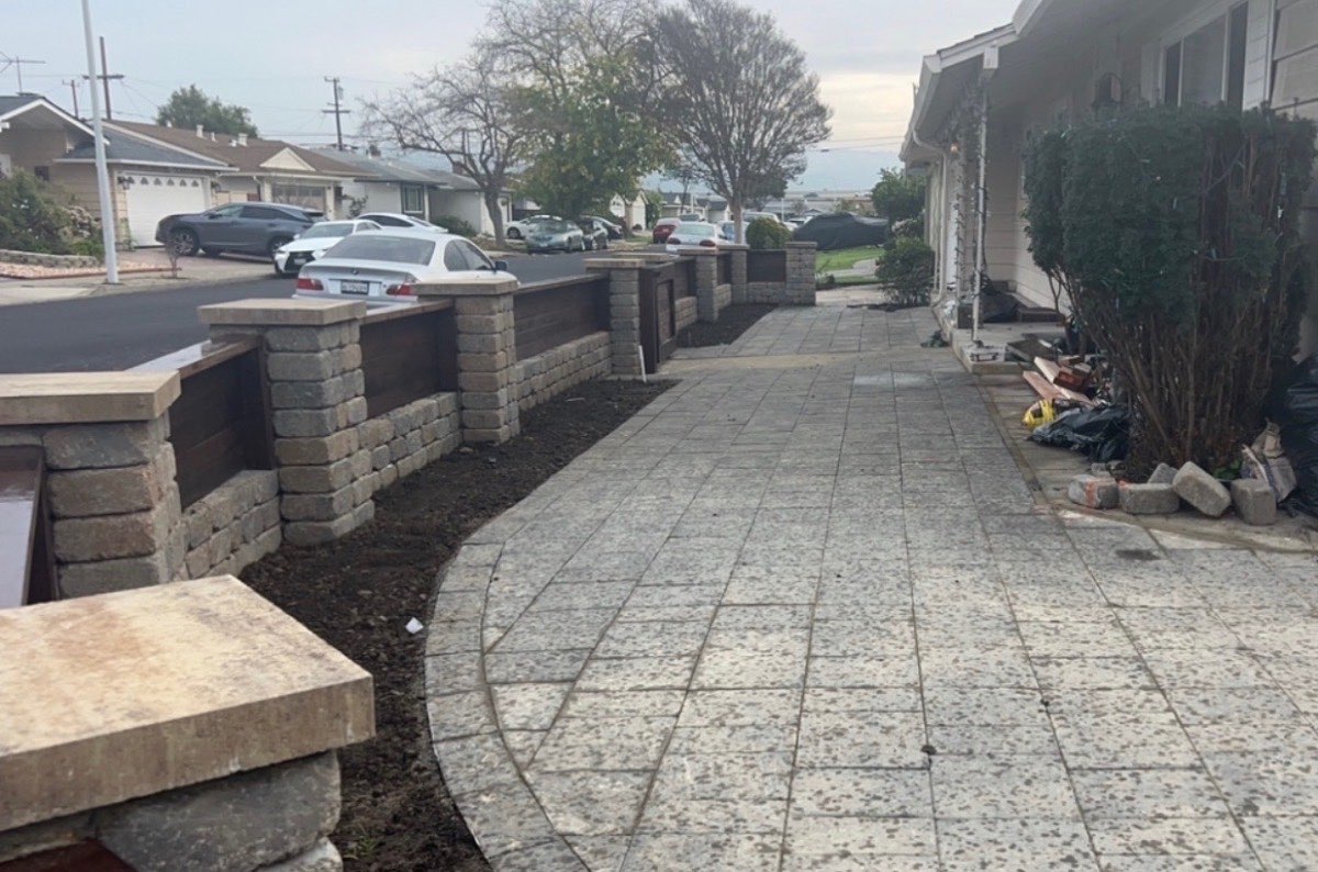 Front yard hardscape with stamped concrete paver walkway and decorative block pillar boundary wall with cap stones