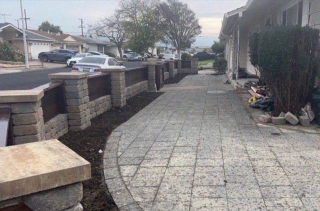 Front yard hardscape with stamped concrete paver walkway and decorative block pillar boundary wall with cap stones