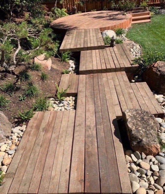 Floating timber deck walkway with river rock dry creek beds and ornamental grasses